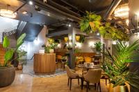 a room with tables and chairs and plants at The Gresham Aparthotel in Leicester