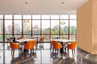 Tivoli at Cultural Heritage Park في تشنغدو: غرفة طعام بها طاولات وكراسي ونوافذ كبيرة