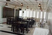 a dining room with tables and chairs and lights at Subhas Tourist Hotel in Jaffna