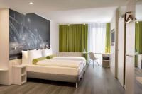 Habitación de hotel con cama y pared verde en Super 8 by Wyndham Mainz Zollhafen, en Mainz