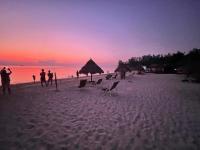 a group of people on the beach at sunset at Nice Sea Resort in Srithanu