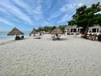 a beach with umbrellas and people laying on the sand at Nice Sea Resort in Srithanu