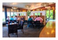 een groep mensen die aan een tafel in een restaurant zitten bij Scenic Hotel Punakaiki in Punakaiki
