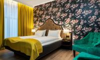 Un dormitorio con una cama y una silla verde. en Thon Hotel Høyers, en Skien