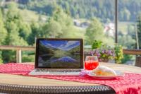 a laptop computer sitting on a table with a glass of wine at Baita Velon in Vermiglio