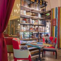 Zimmer mit einem Tisch, Stühlen und Bücherregalen in der Unterkunft Oaks Ibn Battuta Gate Dubai in Dubai