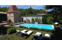 a swimming pool in a yard with chairs and a house at Manoir du Bois Mignon in Le Fleix