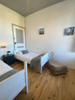 a bedroom with two beds and a mirror and a chair at L&#39;Estanquet Bed and Breakfast pdj offert in Gastes