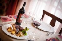 Una mesa con un plato de comida y una botella de vino. en Hotel Fabbrini, en Abbadia San Salvatore