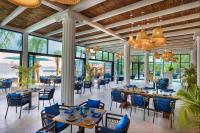 uma sala de jantar com mesas, cadeiras e janelas em Anantara World Islands Dubai Resort no Dubai