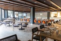 a dining room with tables and chairs and tablesktop at Grand Palladium Sicilia Resort & Spa in Campofelice di Roccella
