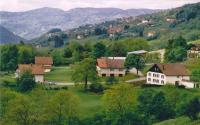 un grupo de casas en una colina con montañas en el fondo en Les Chantenées, en La Bresse