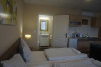 Habitación con cocina con cama y lavamanos en Hotel Ajka Üzletház Panzió Ajka, en Ajka