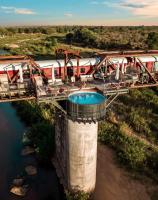 an aerial view of a train crossing a bridge over a river at Kruger Shalati - Train on The Bridge &amp; Garden Suites in Skukuza