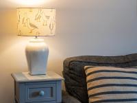 a lamp on a side table next to a couch at Finest Retreats - Old Harbour Cottage in Mevagissey