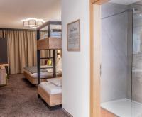 a room with two bunk beds and a shower at Sweet Cherry - Boutique &amp; Guesthouse Tyrol in Innsbruck