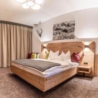 a bedroom with a large bed with a wooden headboard at Sweet Cherry - Boutique &amp; Guesthouse Tyrol in Innsbruck