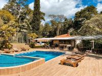 una piscina con sillas y mesas y una casa en Hotel Vila Bavária Petrópolis, en Petrópolis