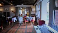 een eetkamer met tafels en stoelen in een restaurant bij L'auberge Du Cochon D'or in Beuzeville