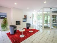 a lobby with two chairs and two tables on a red rug at Holiday Home Cottage Confort 3 Pers- by Interhome in Saumur