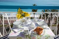 una mesa con un plato de cruasanes y tazas en el balcón en Horizon Blue Lux Apartment, en Niza