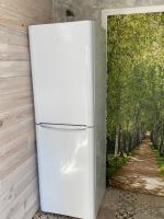 a white refrigerator sitting next to a wall with a painting at Embrun - Appartement 4&#47;6 personnes avec extérieurs in Embrun
