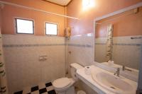 a bathroom with a sink and a toilet and a mirror at Gooddays Lanta Beach Resort SHA in Ko Lanta