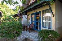 a porch with a blue door and two chairs at Gooddays Lanta Beach Resort SHA in Ko Lanta
