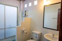 a bathroom with a toilet and a sink and a mirror at Gooddays Lanta Beach Resort SHA in Ko Lanta