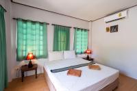 a bedroom with a bed with two lamps on a table at Gooddays Lanta Beach Resort SHA in Ko Lanta