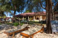a resort with two chairs and a sign in the sand at Gooddays Lanta Beach Resort SHA in Ko Lanta