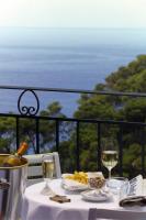 Una mesa con un plato de comida y dos copas de vino. en Hotel La Floridiana, en Capri