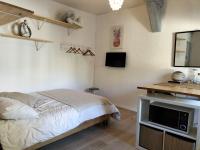 a bedroom with a bed and a desk with a television at STUDIO avec PARKING TOUT A PIED et CALME in Bandol
