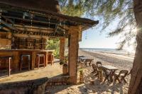 a beach bar with tables and chairs on the beach at Gooddays Lanta Beach Resort SHA in Ko Lanta
