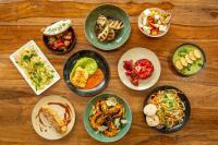 eine Gruppe Teller mit Lebensmitteln auf einem Holztisch in der Unterkunft Mercure Paris Porte d'Orleans in Montrouge