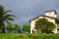 a house with a rainbow in the sky at He Tian Ju Villa in Jiaoxi