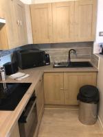 a kitchen with wooden cabinets and a sink and a counter at Hôtel Beau Rivage in Royan