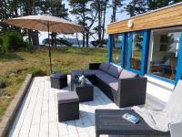 a patio with a couch and chairs and an umbrella at Holiday home in a secluded location surrounded by the sea, Hanvec in Hanvec