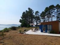 a small house with a deck next to the water at Holiday home in a secluded location surrounded by the sea, Hanvec in Hanvec
