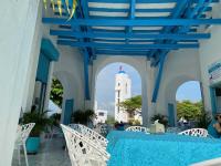 a patio with a blue table and chairs and a tower at Hotel Aldea Plaza in Doradal