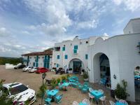 a building with blue tables and chairs in a parking lot at Hotel Aldea Plaza in Doradal