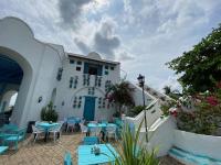 a patio with blue tables and chairs in front of a building at Hotel Aldea Plaza in Doradal