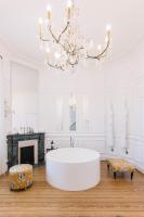 a white bathroom with a large tub and a chandelier at La Course in Bordeaux
