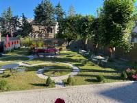 einen Garten mit Tischen und Stühlen und einem Kreis im Gras in der Unterkunft La Demeure De Charme in Troyes