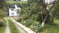 un jardín con flores blancas y una casa blanca en Pensiunea Iulia, en Bran