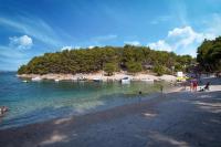 a group of people on a beach with boats in the water at Mobile Home Sea Shell Šime, Drage in Drage