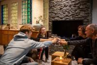 eine Gruppe von Menschen sitzt um einen Tisch und trinkt Wein in der Unterkunft Hotel De Schildkamp in Asperen