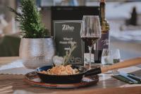 a table with a bowl of food and a glass of wine at loisi's Boutiquehotel in Achenkirch