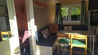 a small room with a table and chairs and a couch at mobil-home du lac de Foix in Foix