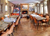 Un restaurante con mesas y sillas y chimenea. en Hôtel Les Cimes, en Megève